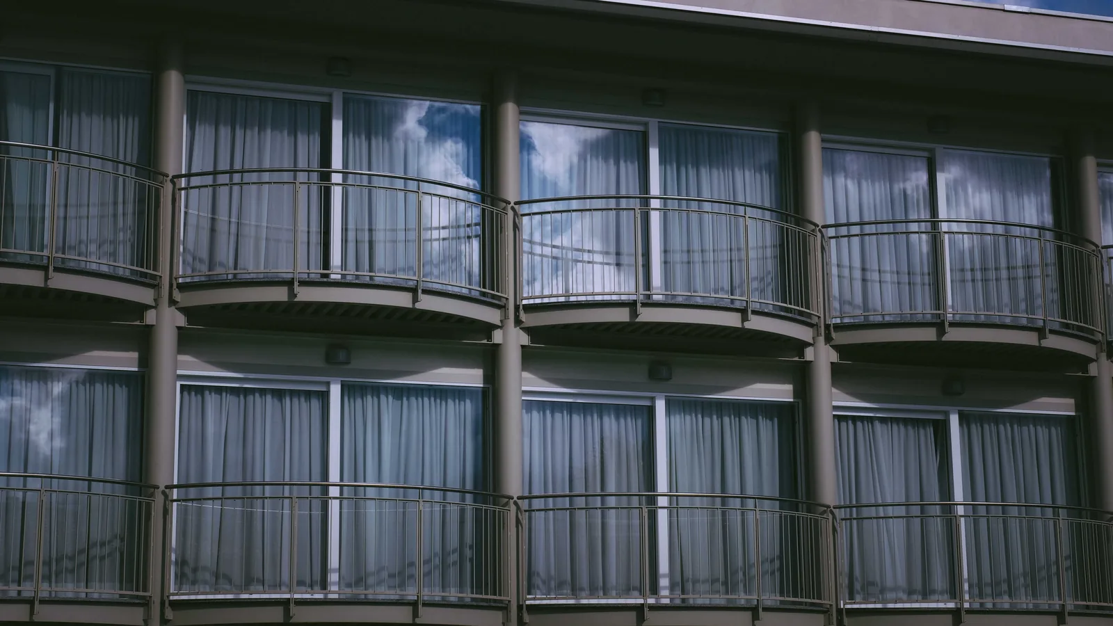 Rows of curved balconies on a multi-story building, seen from below