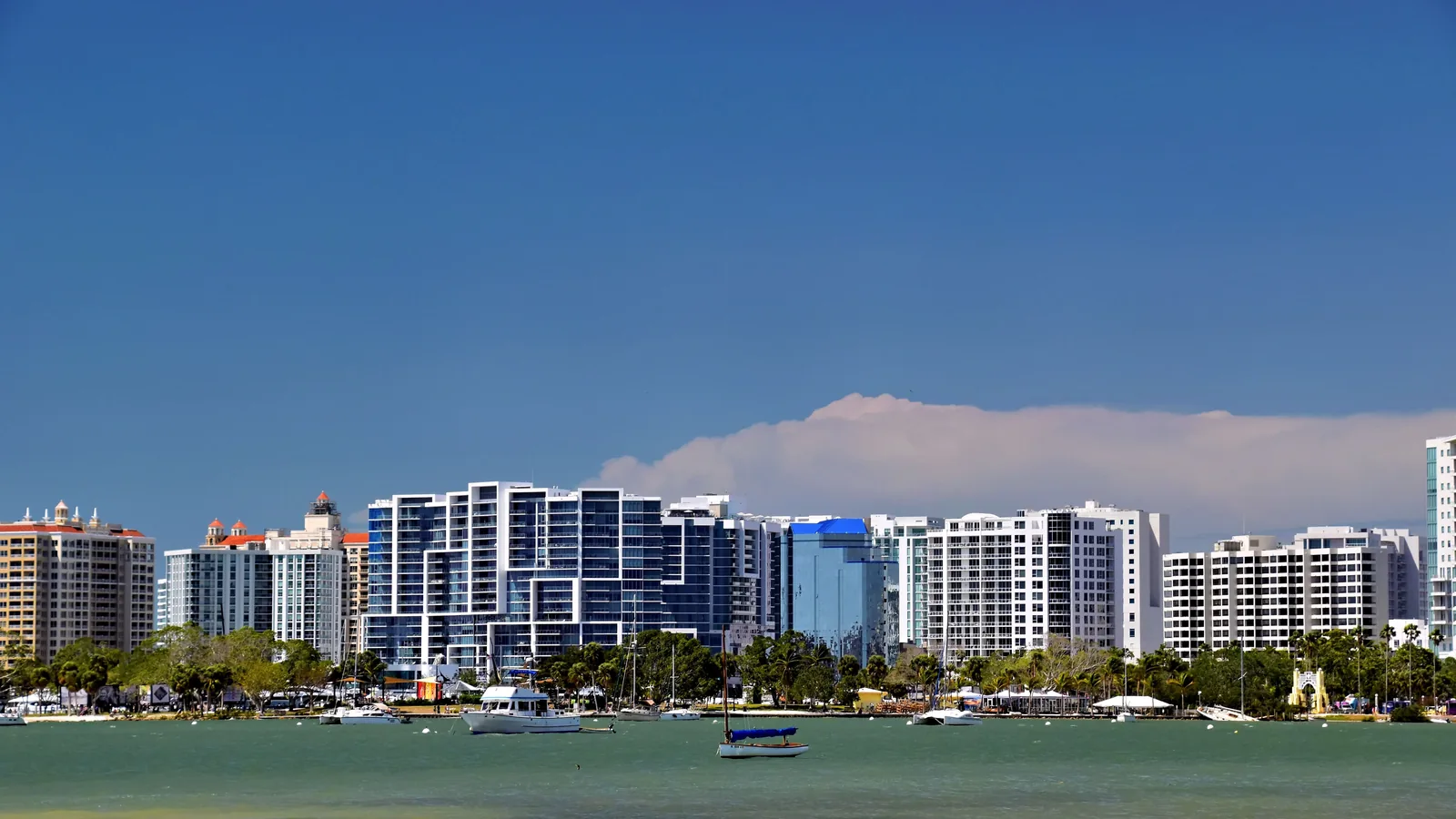 Waterfront condo towers across a harbor under a clear sky