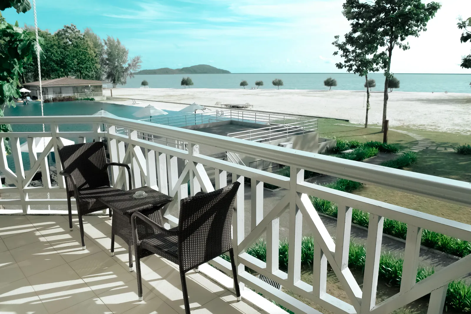 Two chairs and a small table on a balcony with a water view